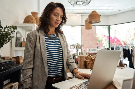 A store manager checking orders on a laptop