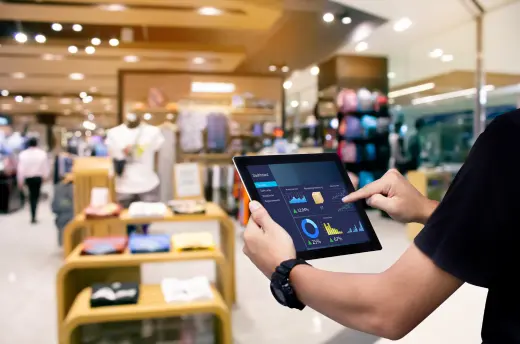 A retailer reviewing store data on a tablet on the shop floor