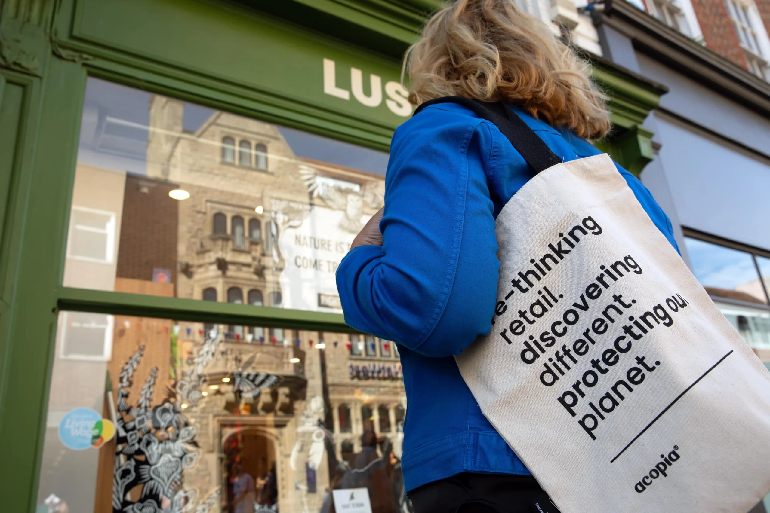A shopper outside a high street store carrying an Acopia re-thinking retail tote bag
